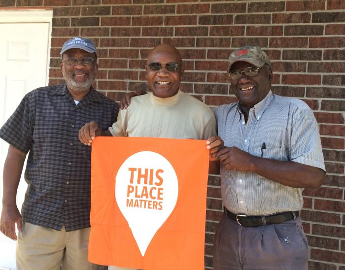 Henry Hadnot, Fred McCray, and Bobbie Hadnot, descendants of Dixie Settlement, a freedom colony in Jasper County, stand in front of a historic school which is now a community center where they share memories and historic photos. Photo by Andrea Roberts. 