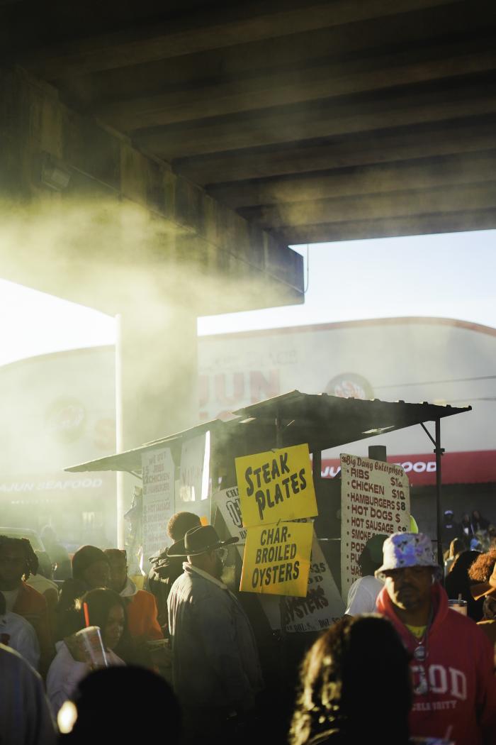 Vendors selling food at a second line parade in New Orleans. Taken below the Claiborne Avenue stretch of I-10 highway in the Tremé neighborhood of New Orleans. Photo credit Fernando López.