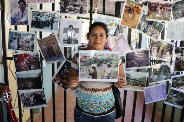 A young woman in Milingo finds a photo of family members working in a refugee camp - photo by Amanda Grzyb