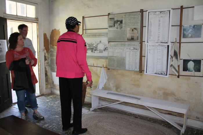 Visitors observing an exhibit at the Burton Place quarters in Holly Springs