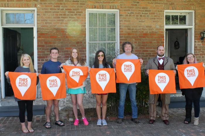 Student visitors and Behind the Big House Program volunteers photographed in front of the Burton Place kitchen/quarters